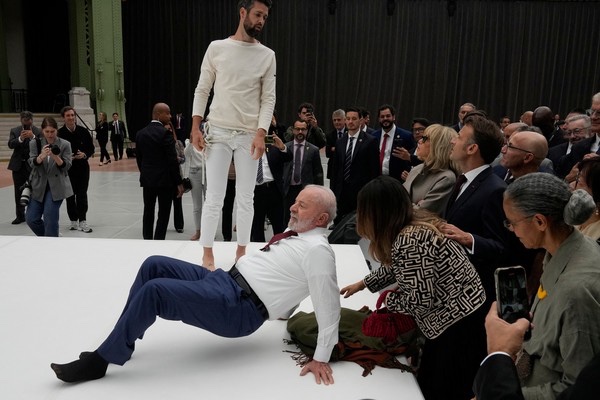 Em Paris, Lula tira os sapatos, deita no chão e participa de performance com acrobatas
